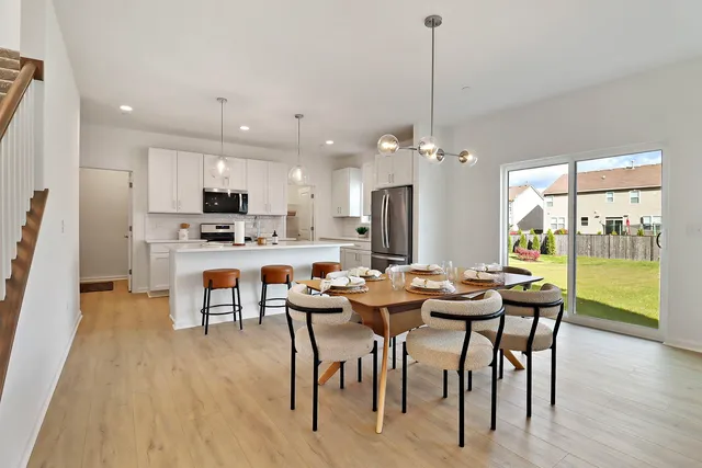 a view of a dining room and livingroom with furniture wooden floor a chandelier