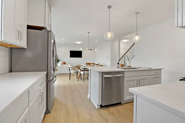 a open kitchen with a sink a stove and chairs
