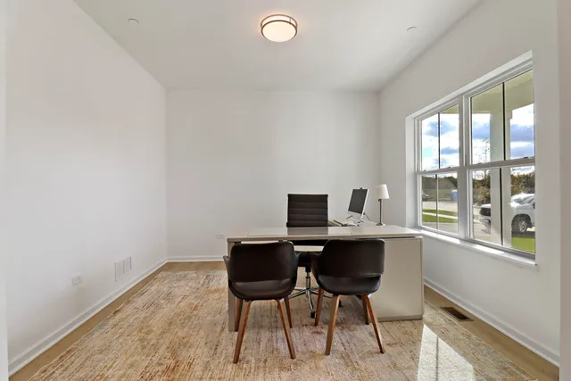 a view of a workspace with furniture and a window