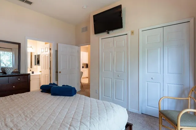 a large bedroom with a bed and a flat screen tv