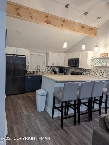 a kitchen with a table chairs refrigerator and microwave