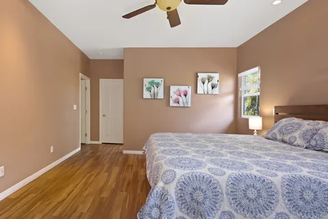 a bedroom with a bed and painting on the wall