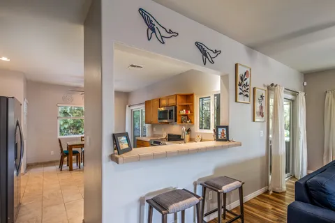 a room with stainless steel appliances kitchen island granite countertop furniture and a view of living room