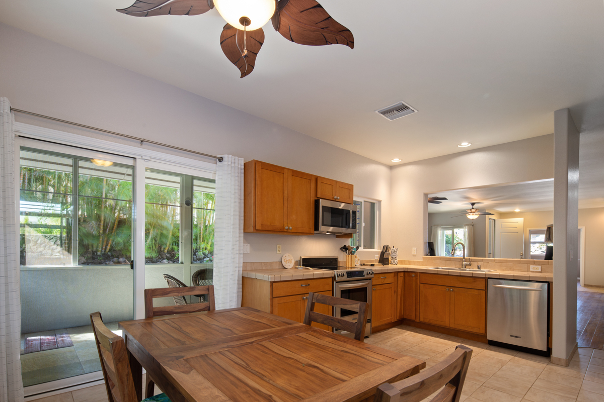 68-1736 Ka'apuni Street Waikoloa, HI 96738 - Photo 10 of 30 a kitchen with a table chairs microwave and cabinets