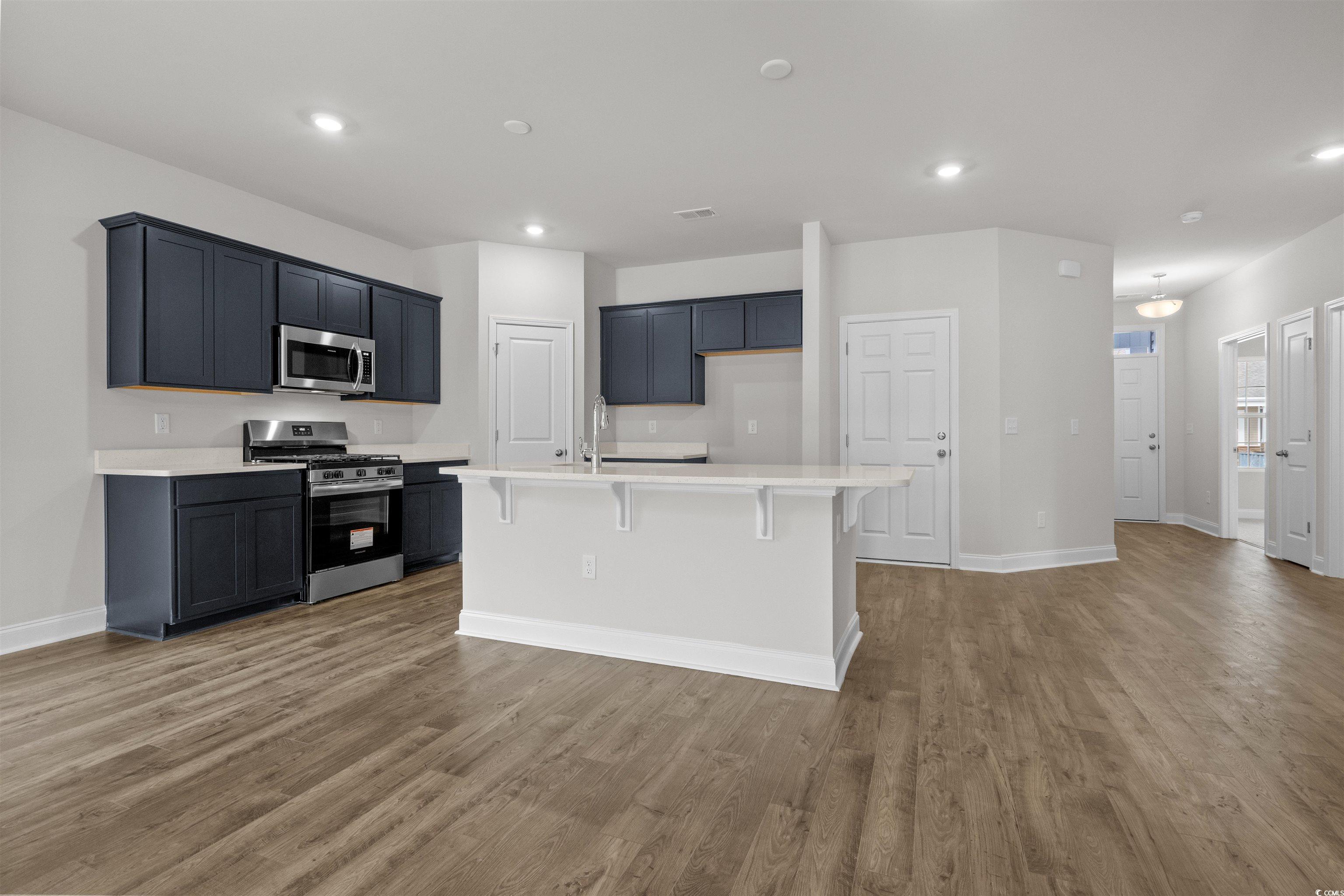 2494 Campton Loop Conway, SC 29527 - Photo 10 of 40 Kitchen with a kitchen bar, appliances with stainless steel finishes, light wood finished floors, a kitchen island with sink, and recessed lighting