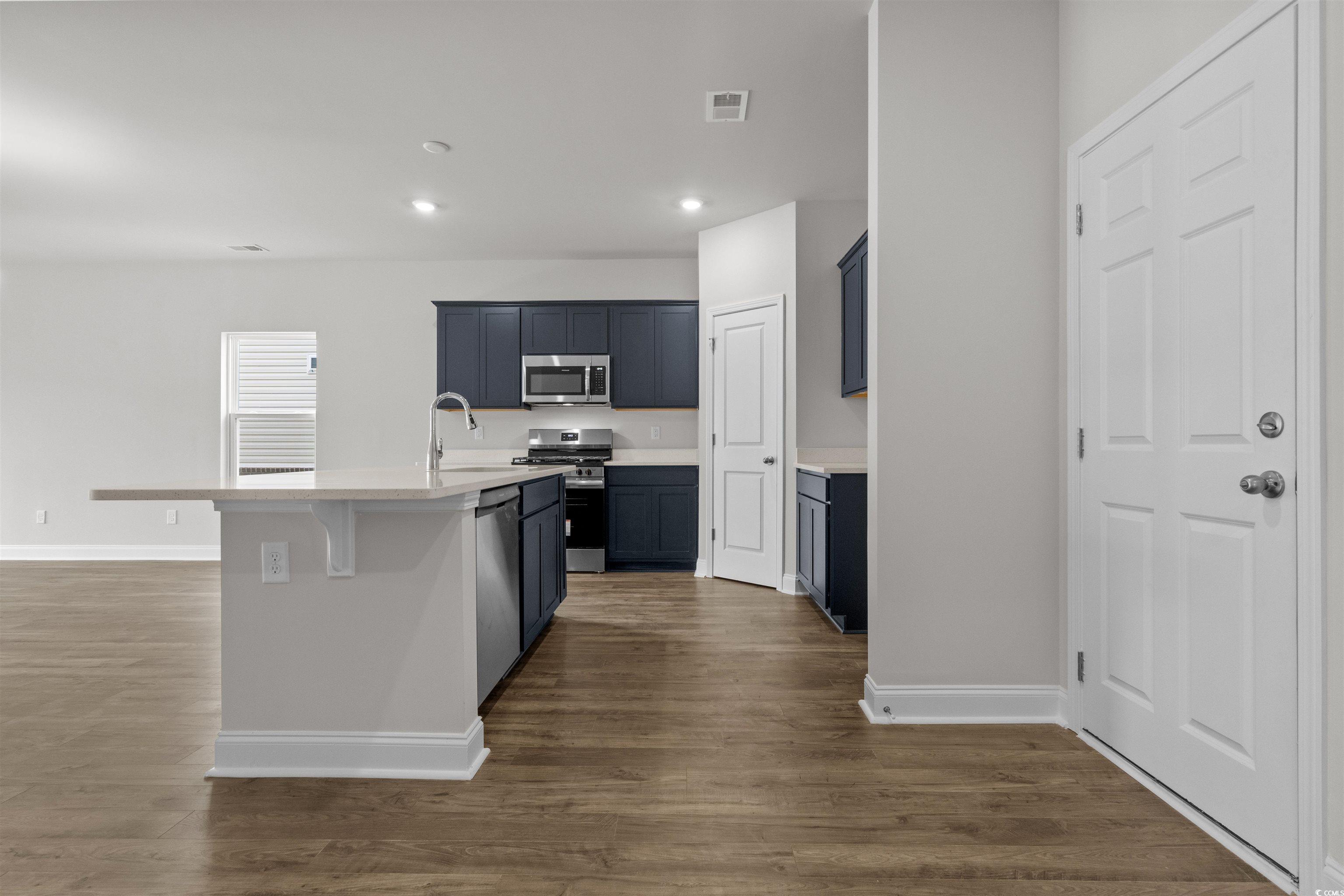 2494 Campton Loop Conway, SC 29527 - Photo 12 of 40 Kitchen with an island with sink, appliances with stainless steel finishes, recessed lighting, a breakfast bar area, and dark wood-style floors