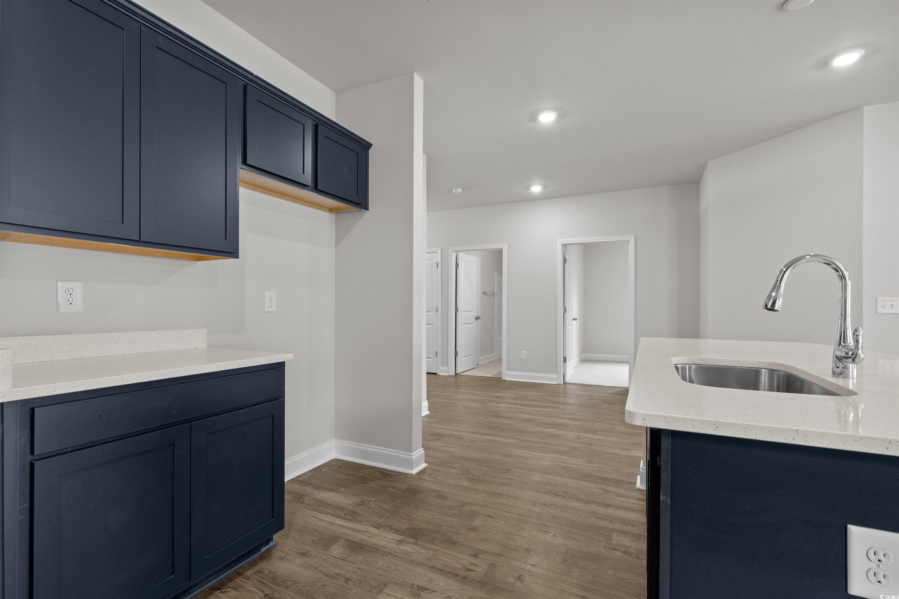 2494 Campton Loop Conway, SC 29527 - Photo 15 of 40 Kitchen with light stone countertops, dark wood-style flooring, recessed lighting, and blue cabinets