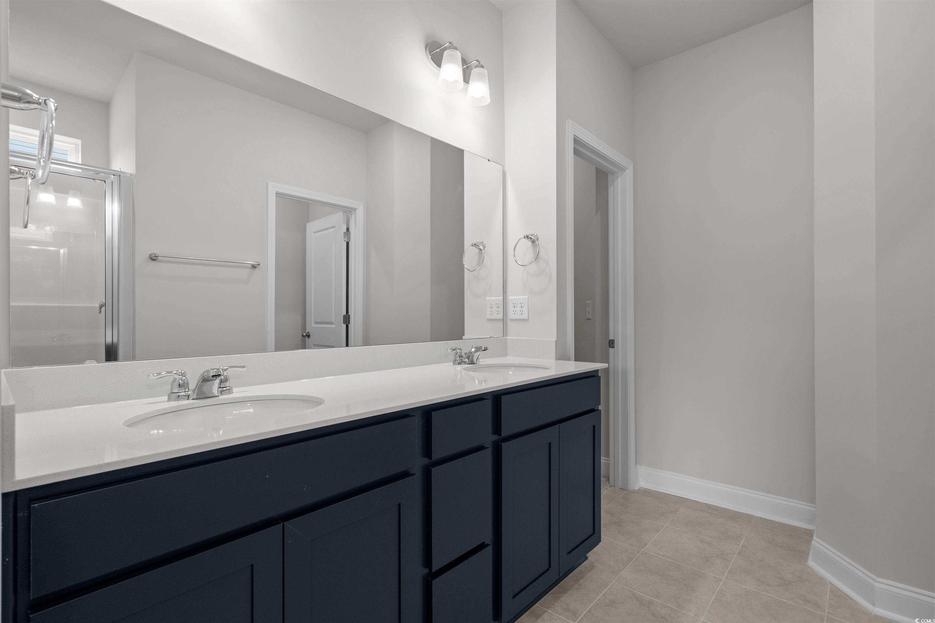 2494 Campton Loop Conway, SC 29527 - Photo 21 of 40 Bathroom featuring double vanity, a shower stall, and light tile patterned floors