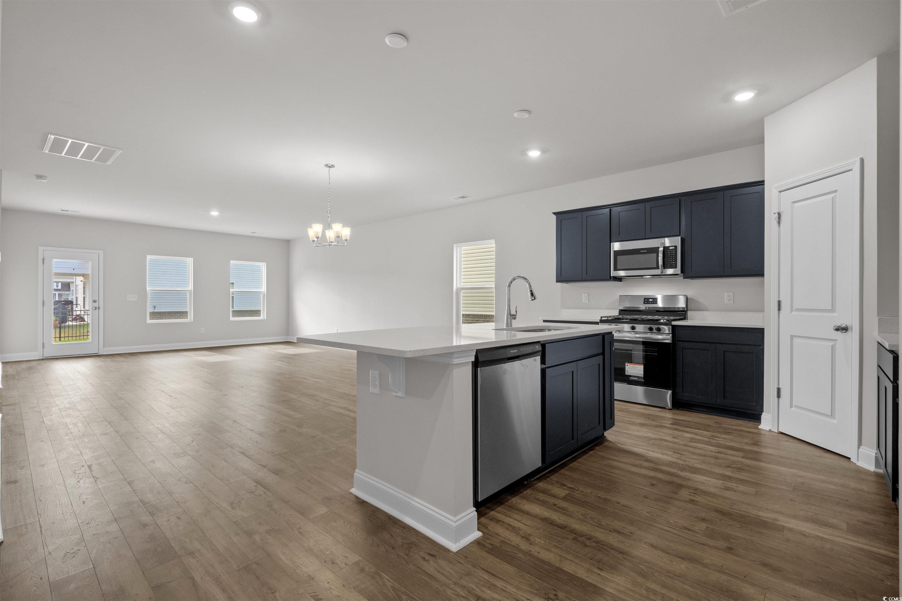 2494 Campton Loop Conway, SC 29527 - Photo 39 of 40 Kitchen with pendant lighting, stainless steel appliances, an island with sink, open floor plan, and dark wood-style flooring