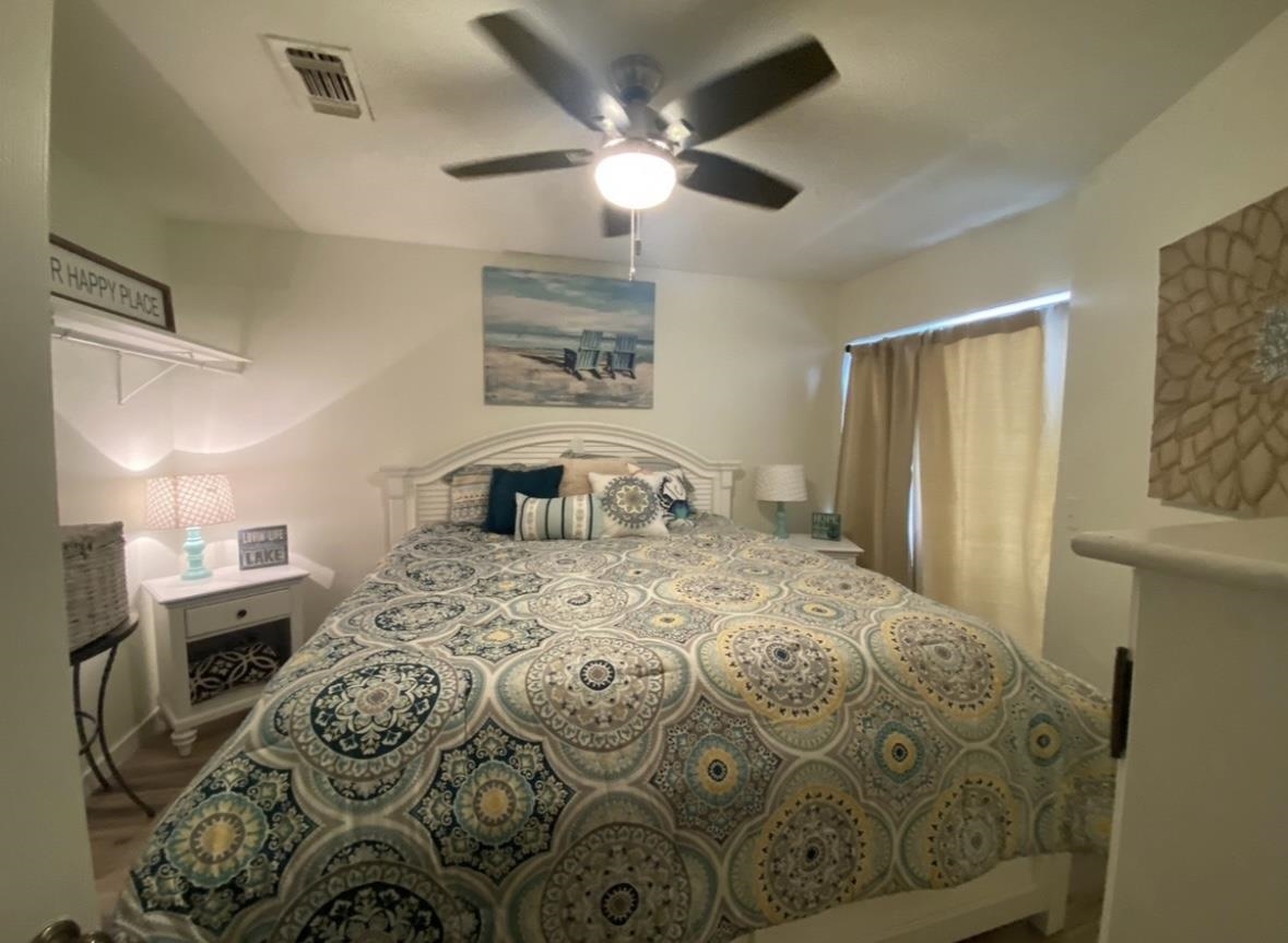 509 Short Circuit, Unit 108 Horseshoe Bay, TX 78657 - Photo 15 of 22 a bedroom with a bed and a chandelier