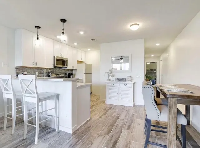 a kitchen with white cabinets and stainless steel appliances