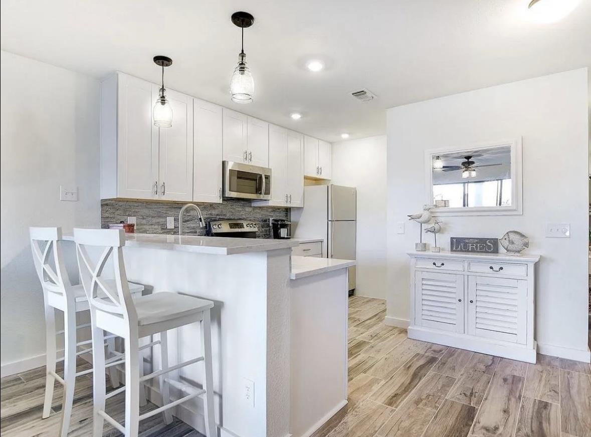 509 Short Circuit, Unit 108 Horseshoe Bay, TX 78657 - Photo 7 of 22 a kitchen with white cabinets and stainless steel appliances