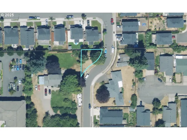 an aerial view of residential houses with outdoor space and parking