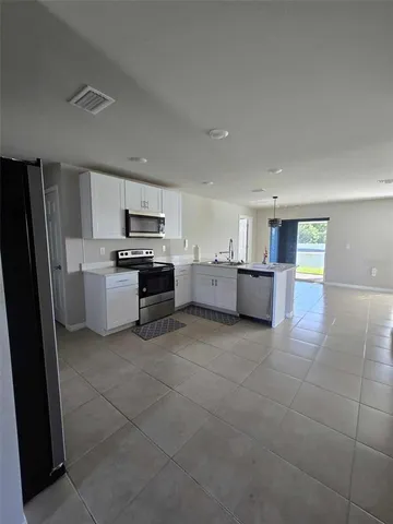 a open kitchen with cabinets and stainless steel appliances