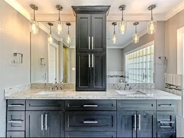 a bathroom with a granite countertop sink a mirror and a shower
