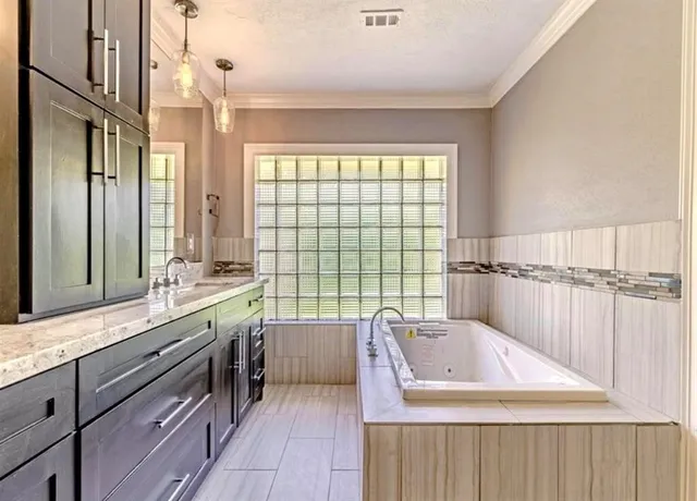 a bathroom with a granite countertop sink a large mirror and a bathtub with shower