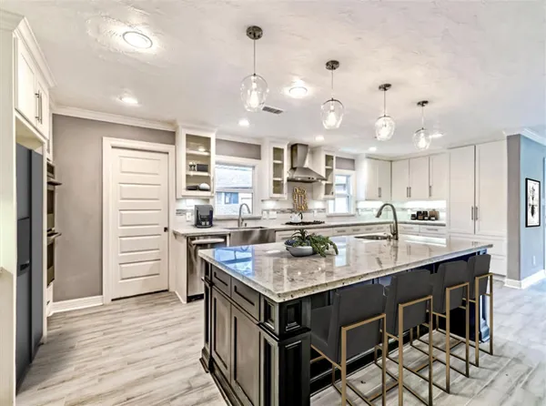 a kitchen with a stove center island cabinets and wooden floor