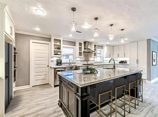 a kitchen with a stove center island cabinets and wooden floor