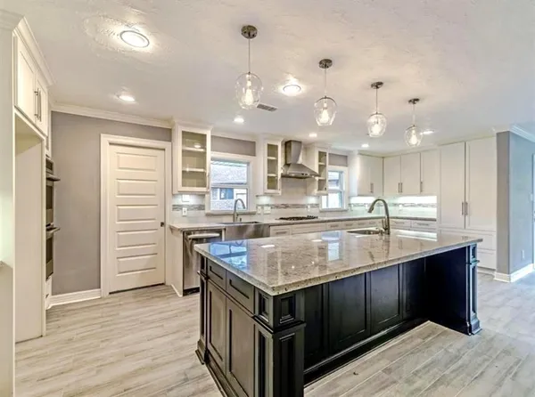 a kitchen with kitchen island a counter space a sink appliances and cabinets