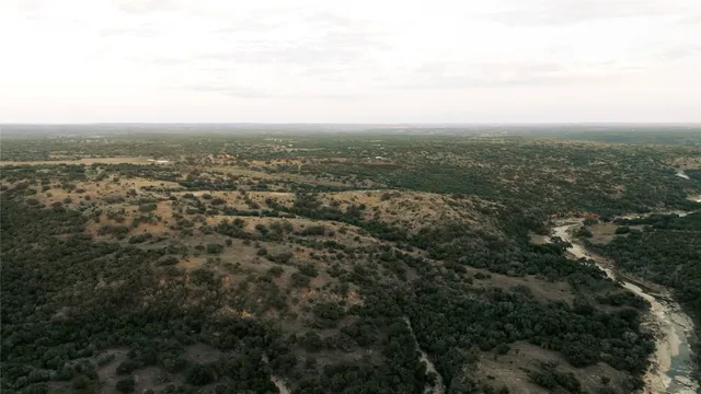 an aerial view of house with yard and mountain view in back