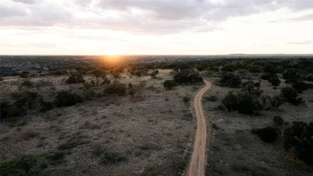 an aerial view of house with yard and mountain view in back