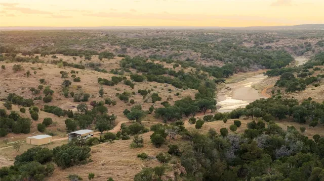 an aerial view of house with yard and mountain view in back