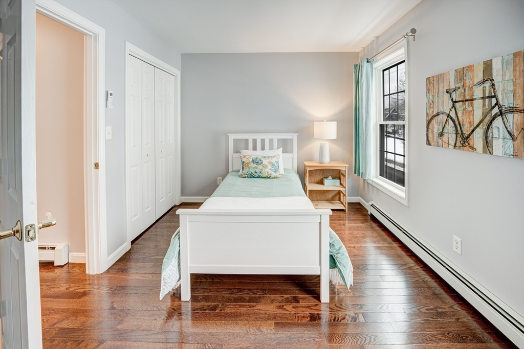 900 Lawrence Street, Unit 5 Lowell, MA 01852 - Photo 15 of 41 a bedroom with a bed and wooden floor