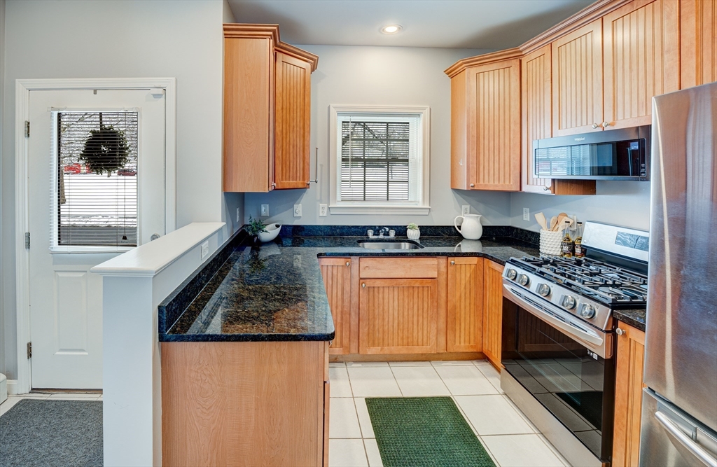 900 Lawrence Street, Unit 5 Lowell, MA 01852 - Photo 4 of 41 a kitchen with stainless steel appliances granite countertop a stove a sink and a microwave