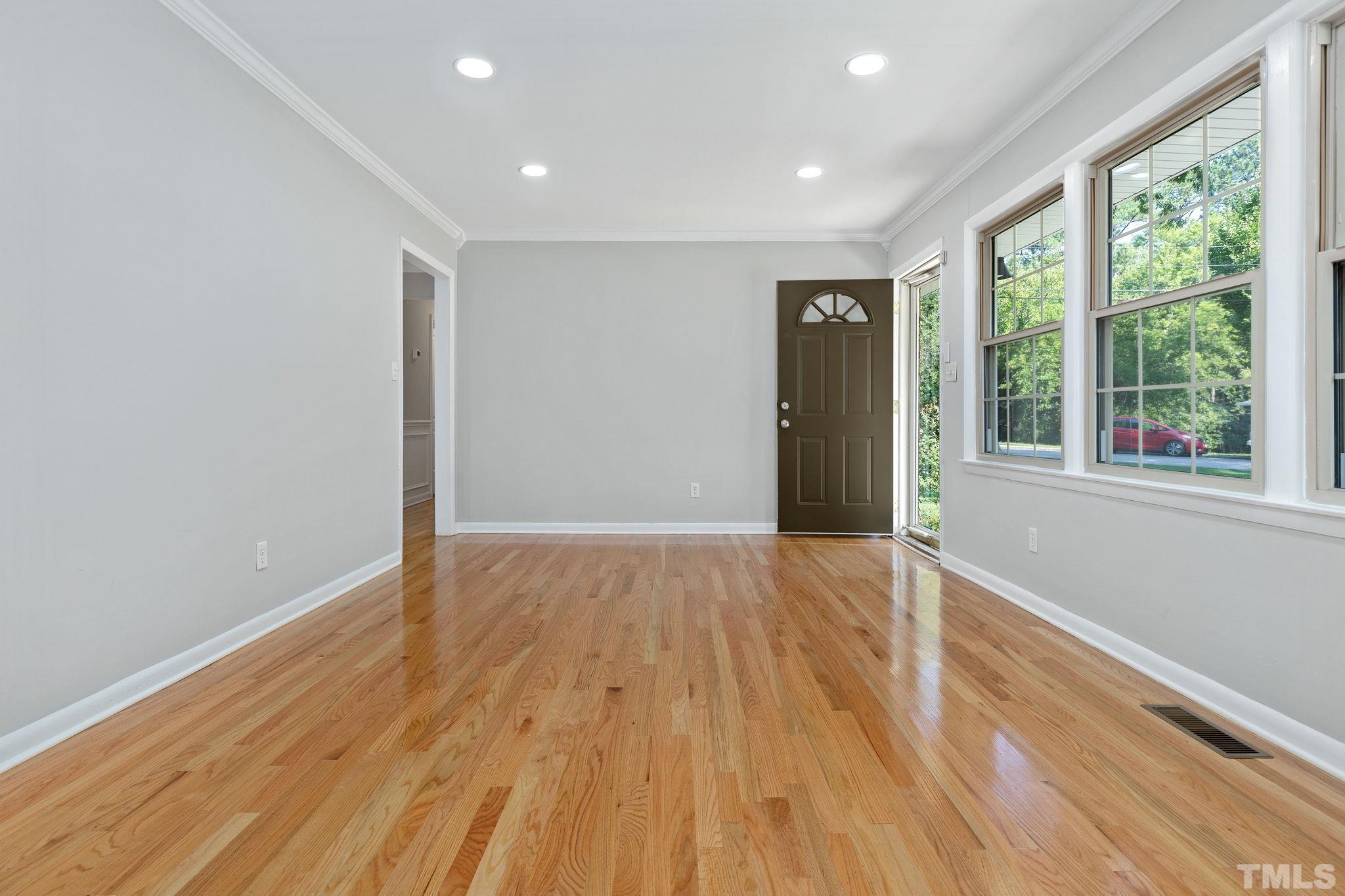 817 Chatham Lane Raleigh, NC 27610 - Photo 8 of 33 a view of an empty room with wooden floor and a window