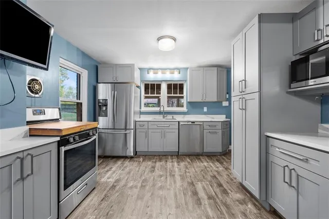 a kitchen with stainless steel appliances a stove a sink and a refrigerator