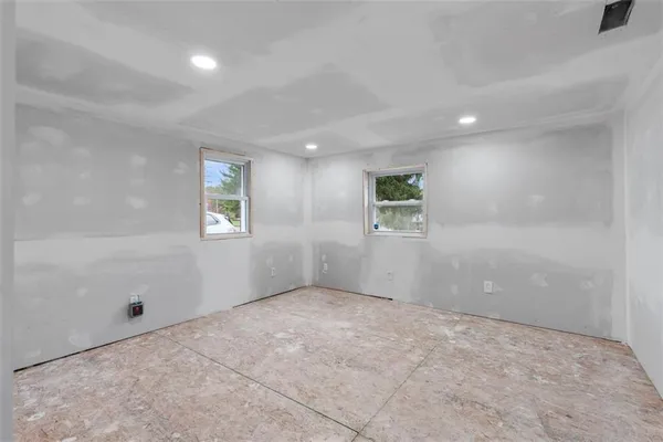 an empty room with windows and closet