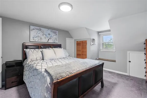 a bed sitting in a bedroom next to a window