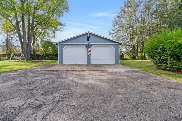 a view of a house with a yard and large trees