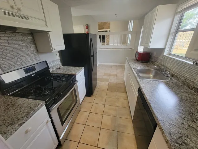 a kitchen with granite countertop a stove and a refrigerator