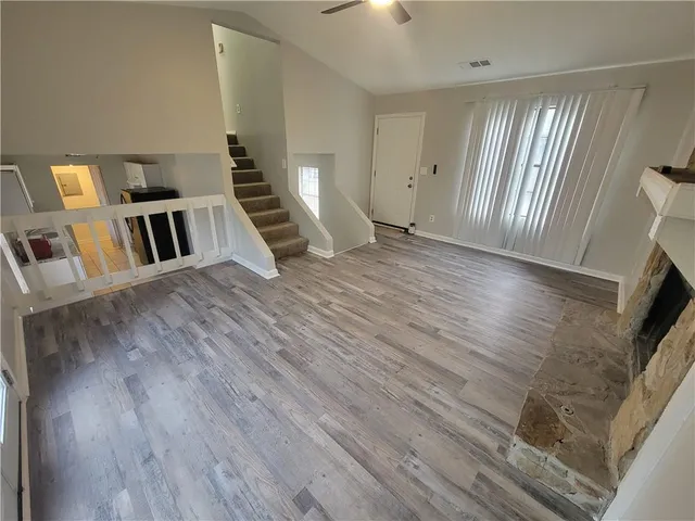 a view of a livingroom with wooden floor and staircase
