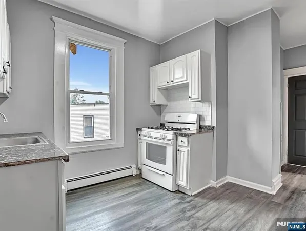 a kitchen with granite countertop white cabinets and white appliances