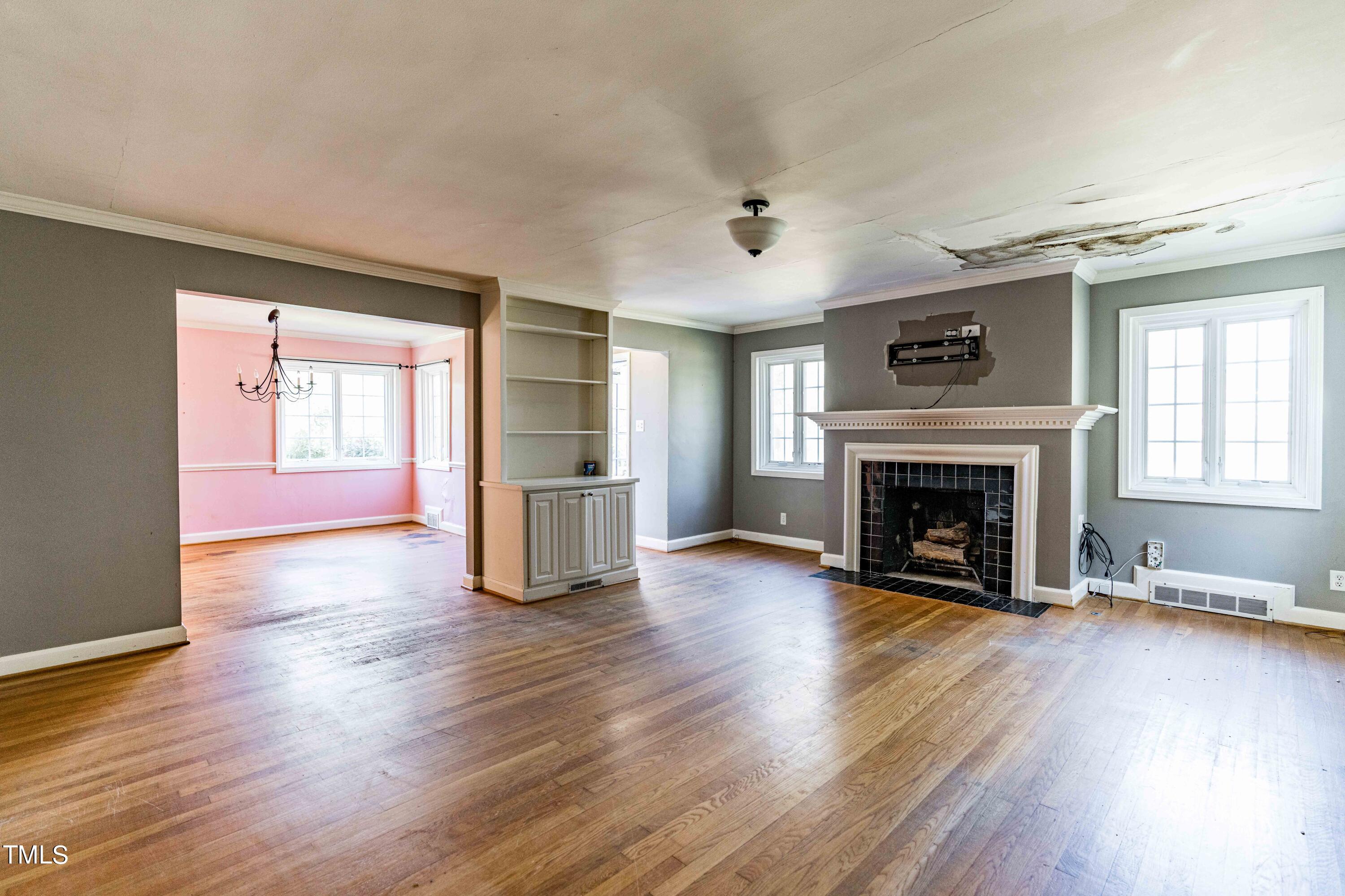 903 Lake Boone Trail Raleigh, NC 27607 - Photo 6 of 25 an empty room with wooden floor fireplace and windows