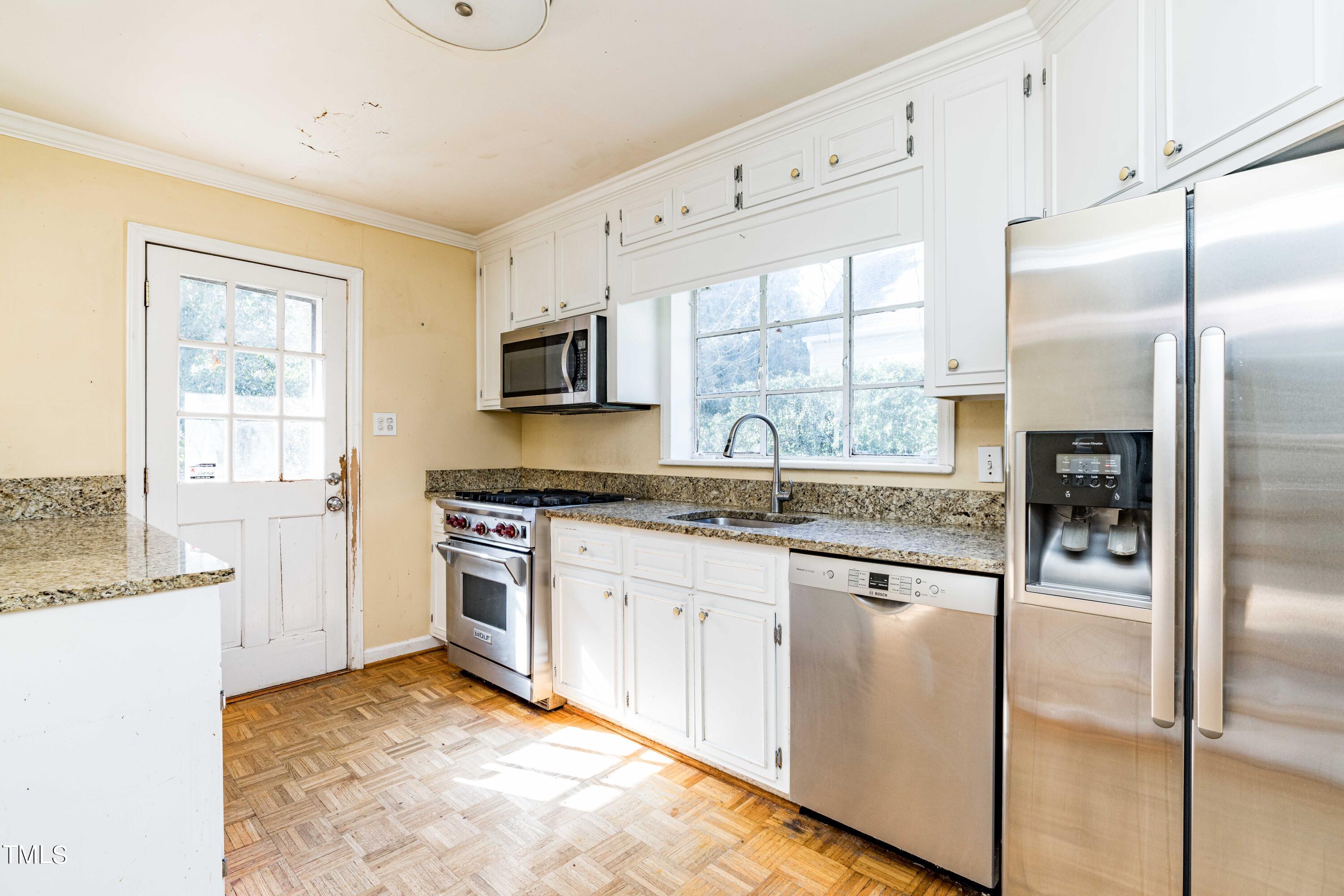 903 Lake Boone Trail Raleigh, NC 27607 - Photo 8 of 25 a kitchen with stainless steel appliances granite countertop a stove a sink and a refrigerator