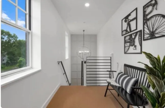 a view of a hallway with stairs and a window