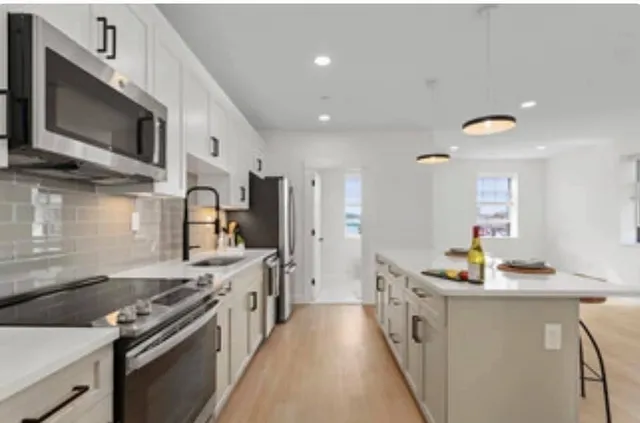 a kitchen with stainless steel appliances a stove a sink and a microwave