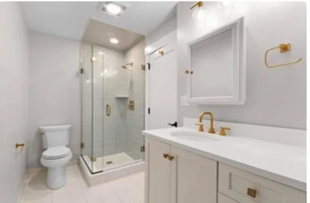 a bathroom with a shower sink mirror and toilet
