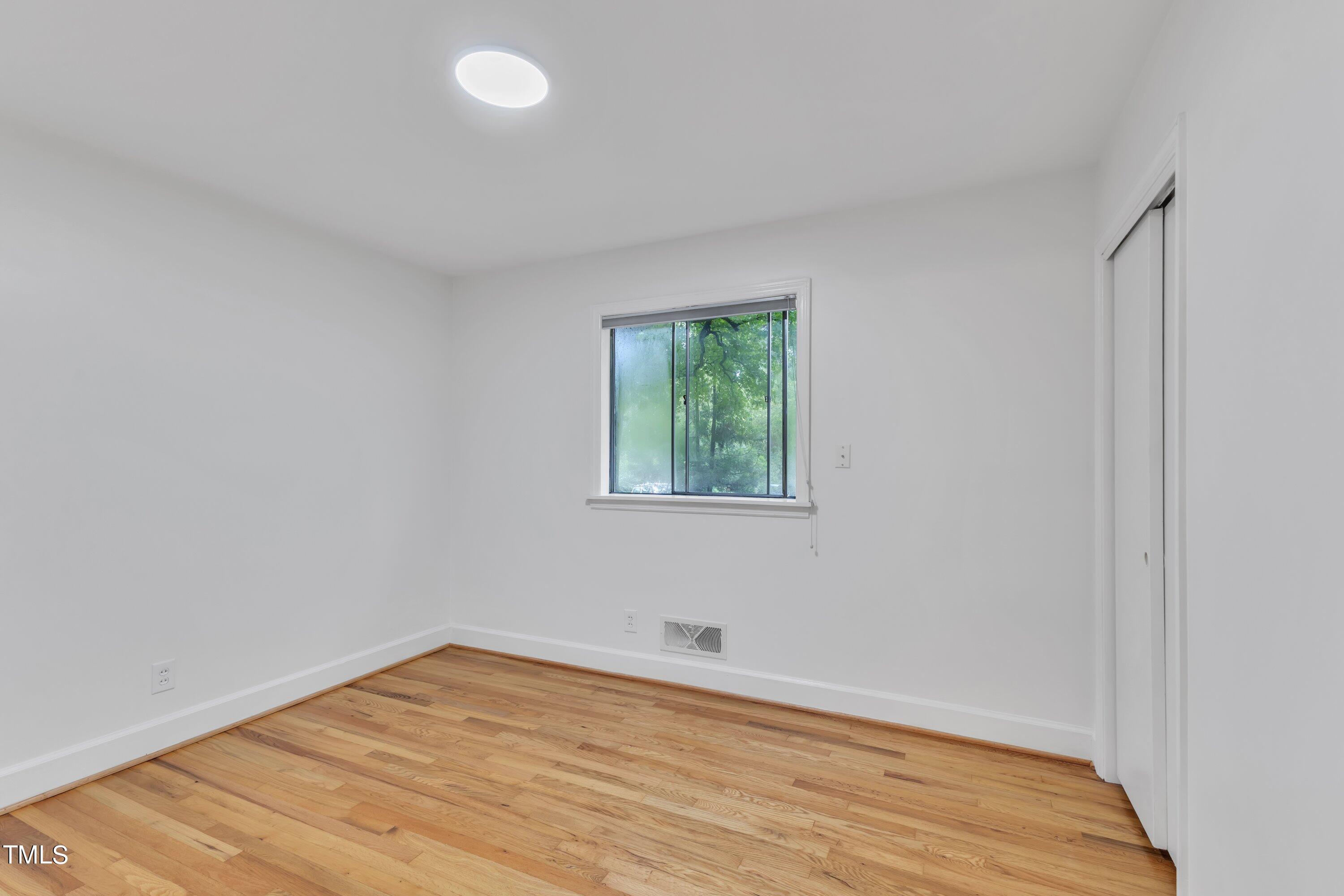 3317 Scott Drive Raleigh, NC 27604 - Photo 14 of 29 a view of an empty room with wooden floor and a window