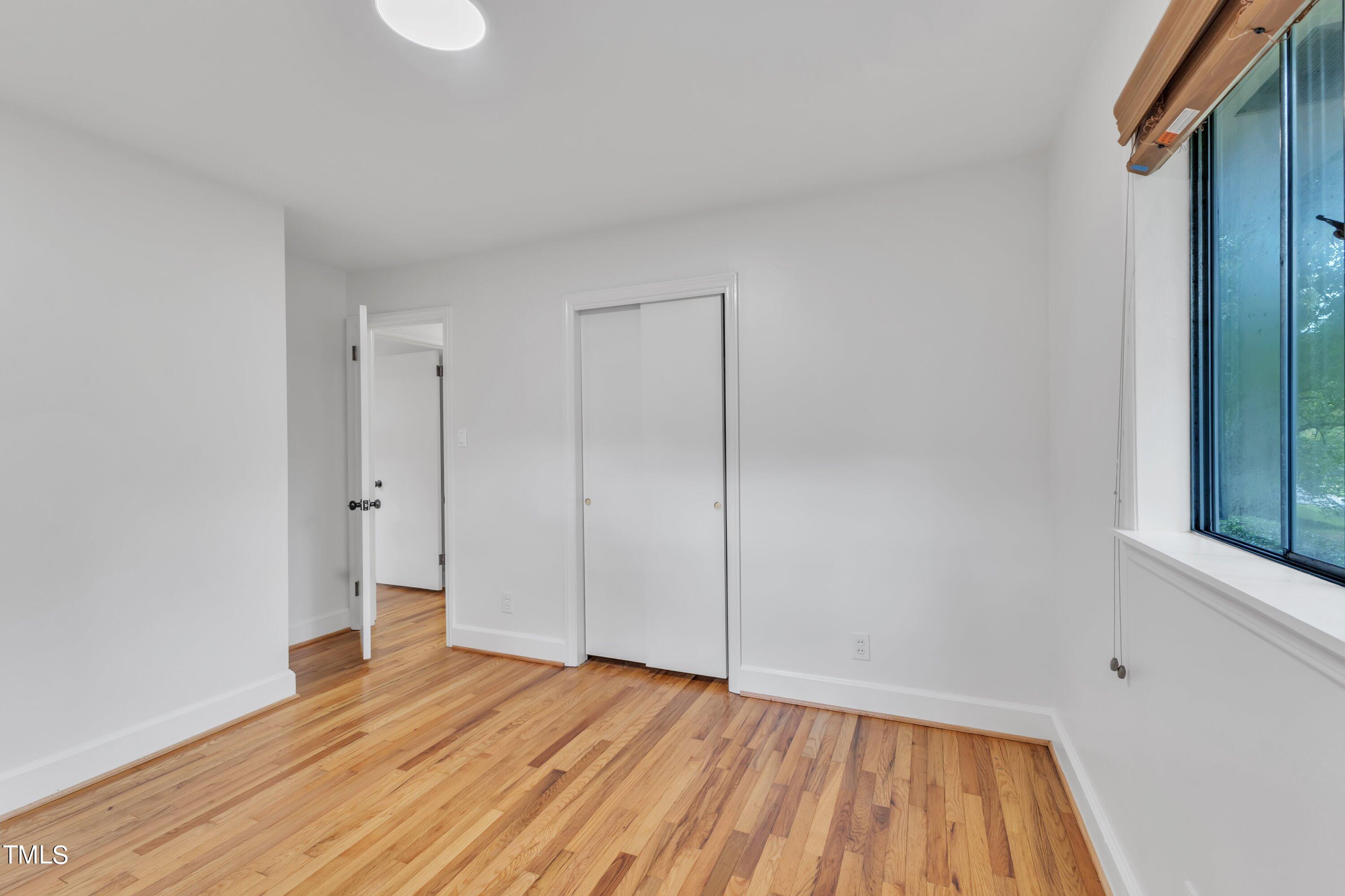 3317 Scott Drive Raleigh, NC 27604 - Photo 17 of 29 a view of an empty room with wooden floor and a window