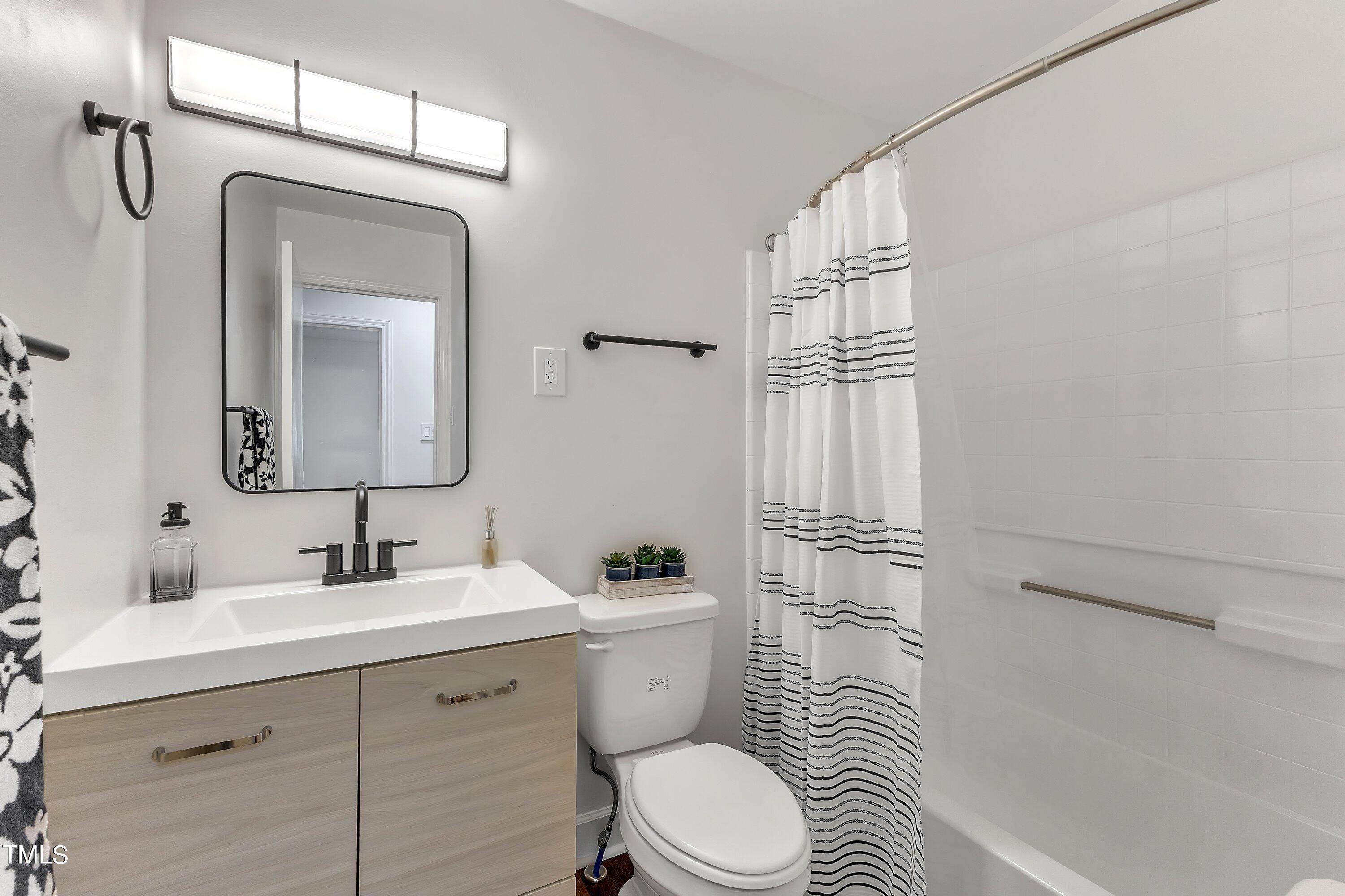 3317 Scott Drive Raleigh, NC 27604 - Photo 23 of 29 a bathroom with a toilet a sink a glass door a shower and a mirror