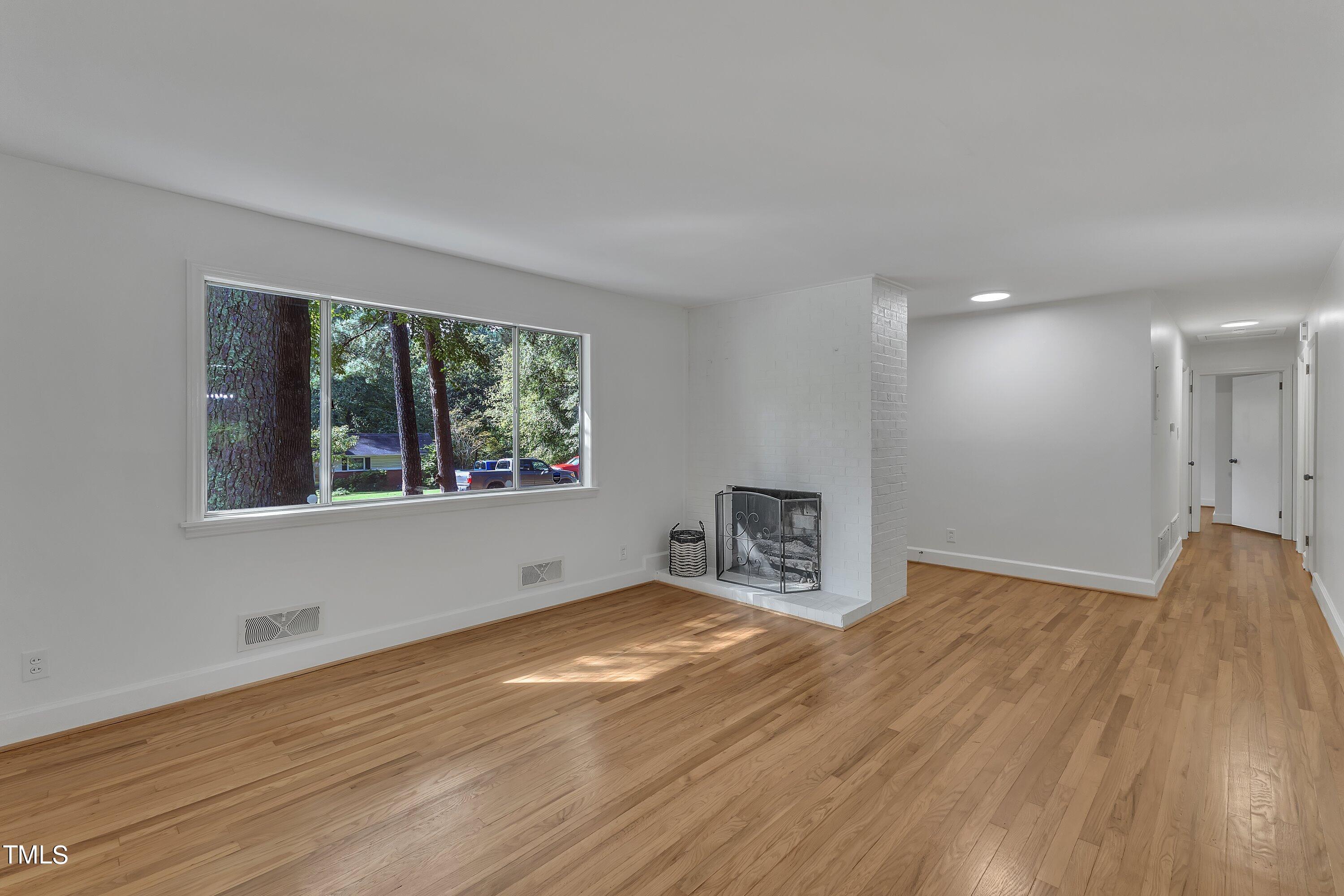3317 Scott Drive Raleigh, NC 27604 - Photo 4 of 29 a view of an empty room with wooden floor and a window