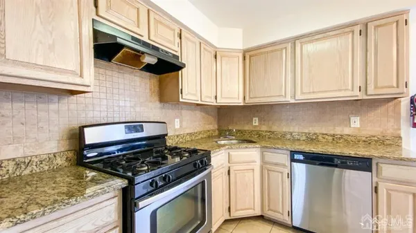 a kitchen with white cabinets and appliances