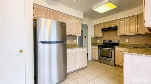 a kitchen with a refrigerator and a stove top oven