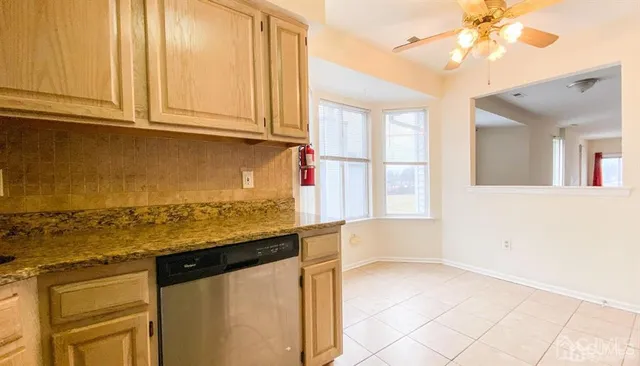 a kitchen with granite countertop a sink a stove and cabinets