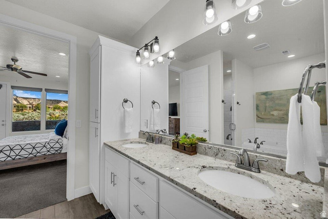5010 Escapes Drive St. George, UT 84770 - Photo 11 of 46 Ensuite bathroom with double vanity, a stall shower, a garden tub, ceiling fan, and dark wood finished floors