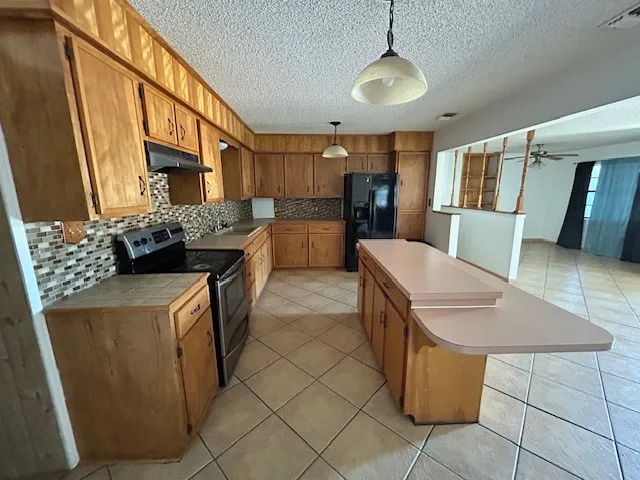 a kitchen with a sink a counter top space and stainless steel appliances